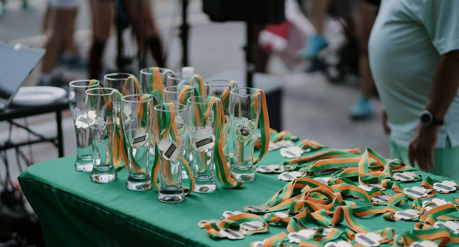 Shamrock medals and awards glasses on a green table at the Top of the Morning 5K