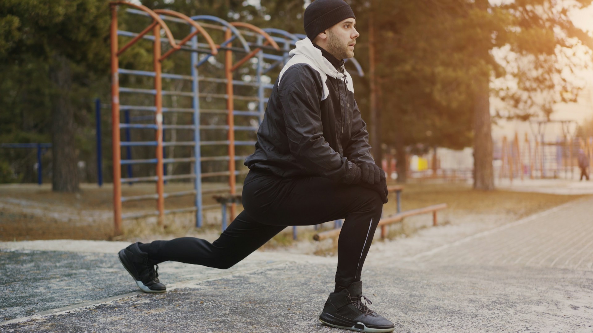 Runner stretching outdoors in layered cool-weather clothing