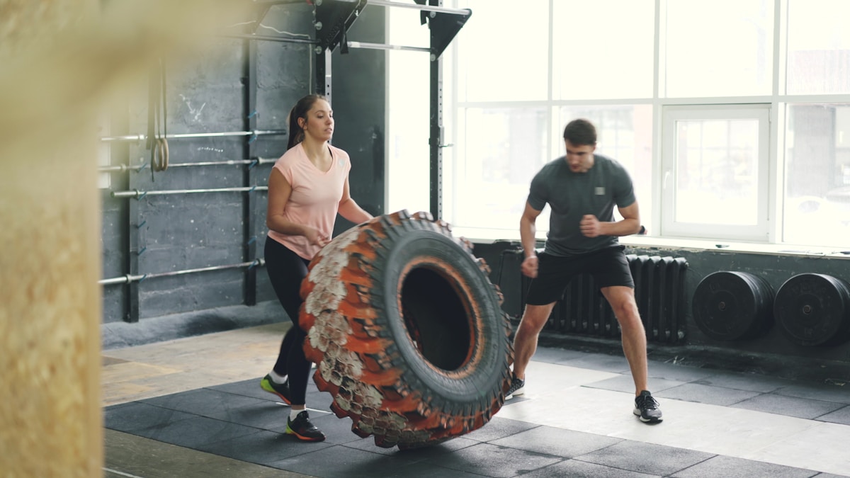 Athletes doing tire-flip strength training